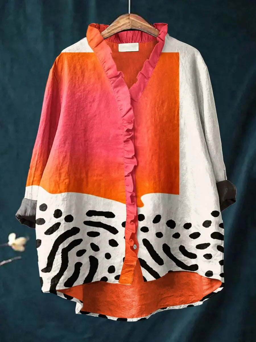 Pink, orange and white print blouse with a ruffle placket on a hanger
