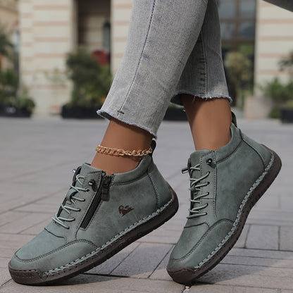 Women's lace-up side zip sneakers in green, side and front view on a street