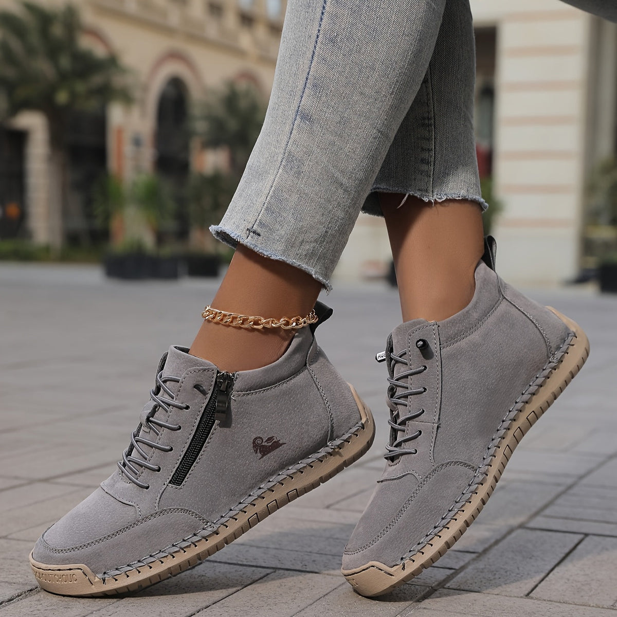 Women's lace-up side zip sneakers in gray, side view on a street