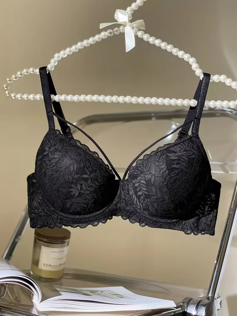 Black strappy lace bra hanging on a pearl hanger
