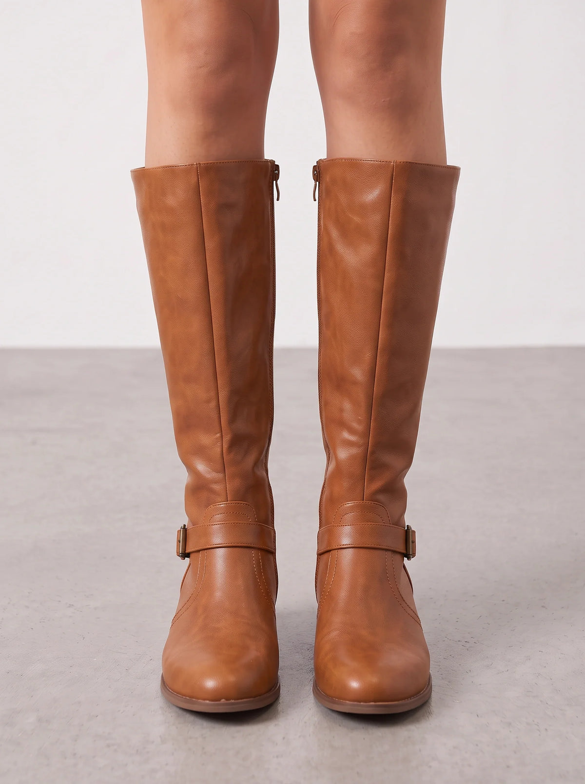 Tan leather riding boots seen from the front on bare legs