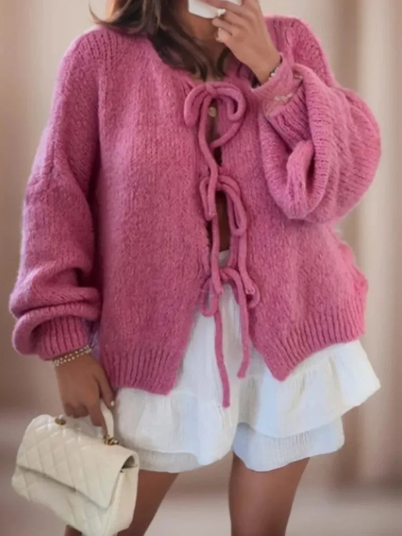 Pink tie front knit cardigan on a model with white ruffle shorts, front view