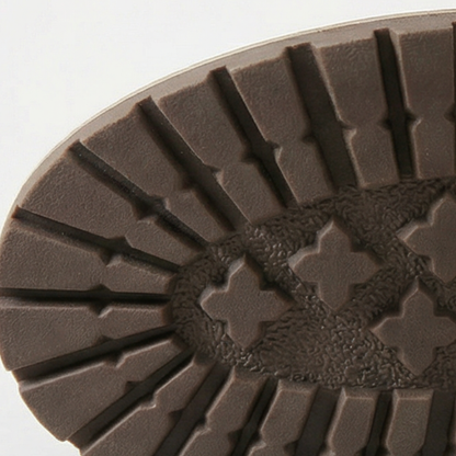 Stacked heel and treaded outsole of a grey ankle bootie