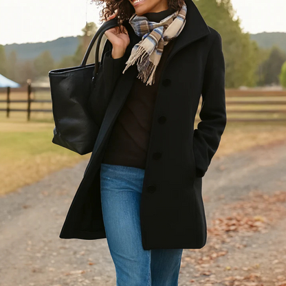 Black button-front longline winter coat worn with jeans