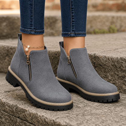 Grey suede ankle boots with gold side zips and chunky platform soles, worn with blue jeans