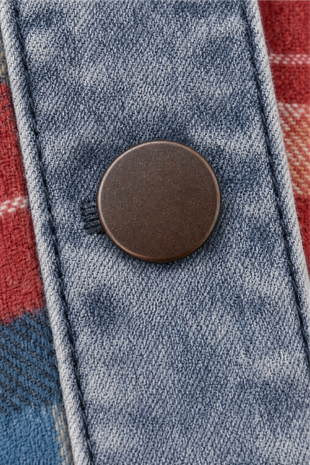 Antique metal snap button on a denim trimmed placket