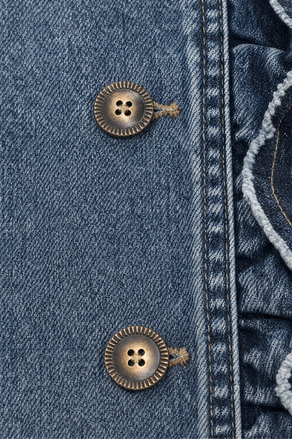 Two antique buttons on the ruffled front of a denim jacket