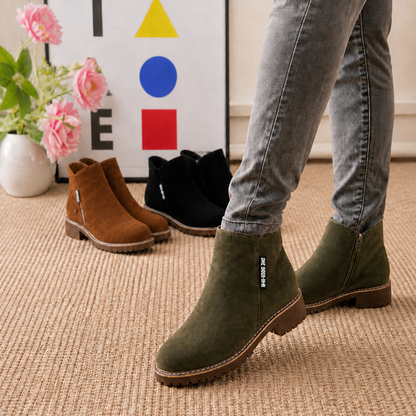 Olive suede ankle boots with side zip worn with grey jeans, brown and black pairs behind