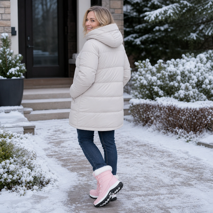 Back view of pink snow boots on a snowy driveway