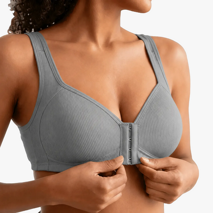 Hands fastening the front closure of a grey ribbed bra