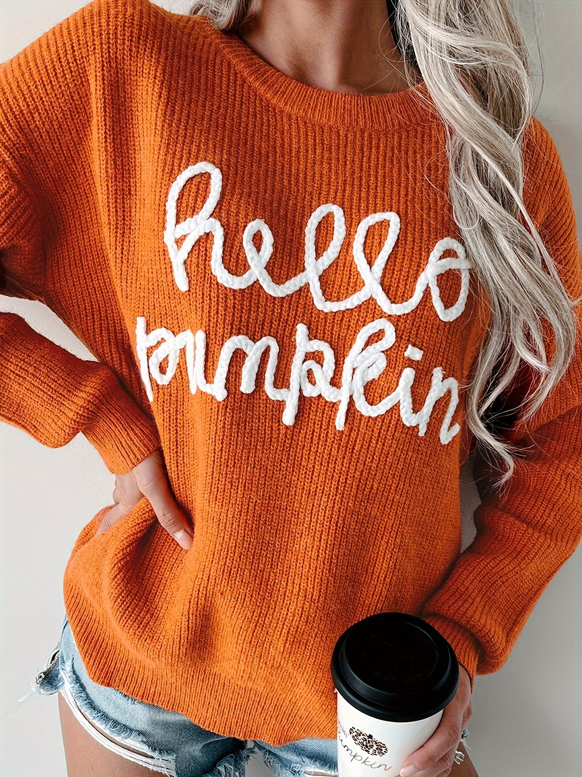 Orange ribbed knit sweater with white hello pumpkin embroidered in script lettering