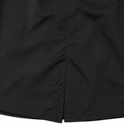 Side vent at the hem of a black longline coat