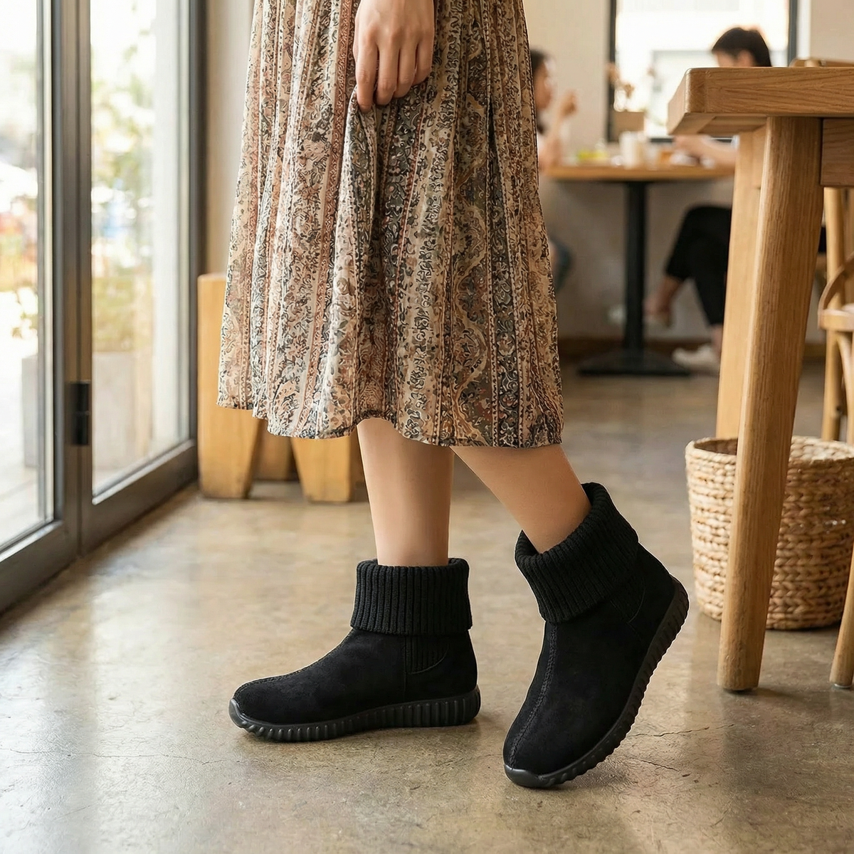 Black knit cuff suede booties worn with a floral midi skirt