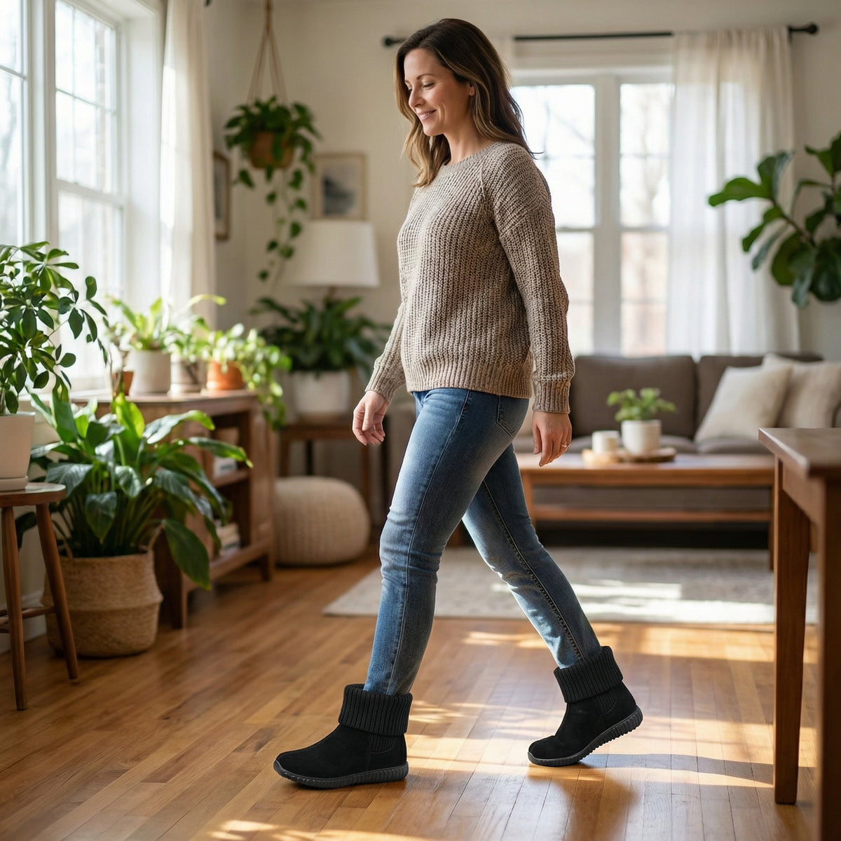 Woman walking indoors in black knit cuff suede booties