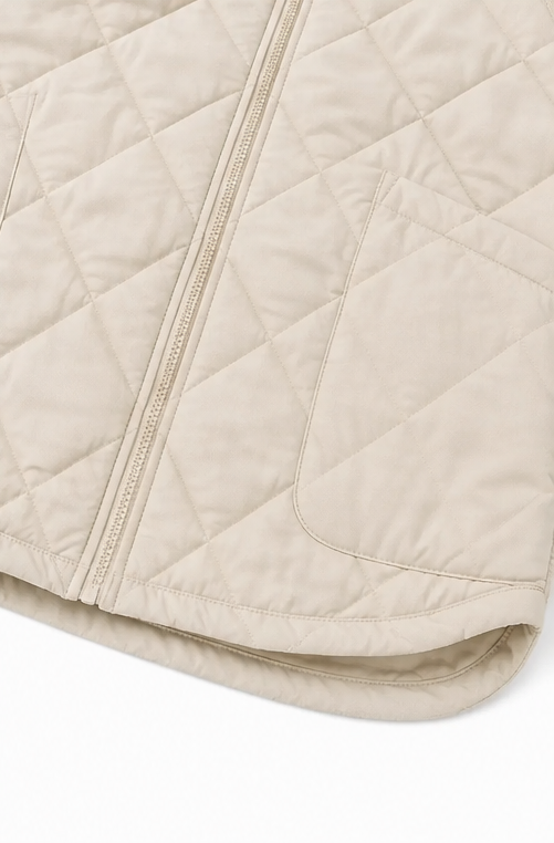 Curved quilted hem and side pocket on a cream jacket