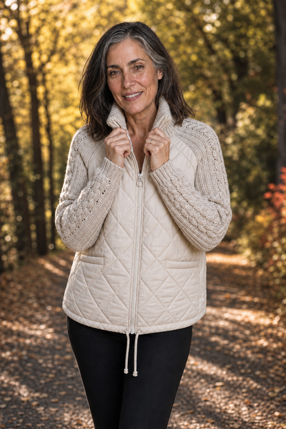 Woman outdoors in a cream quilted jacket with cable knit sleeves