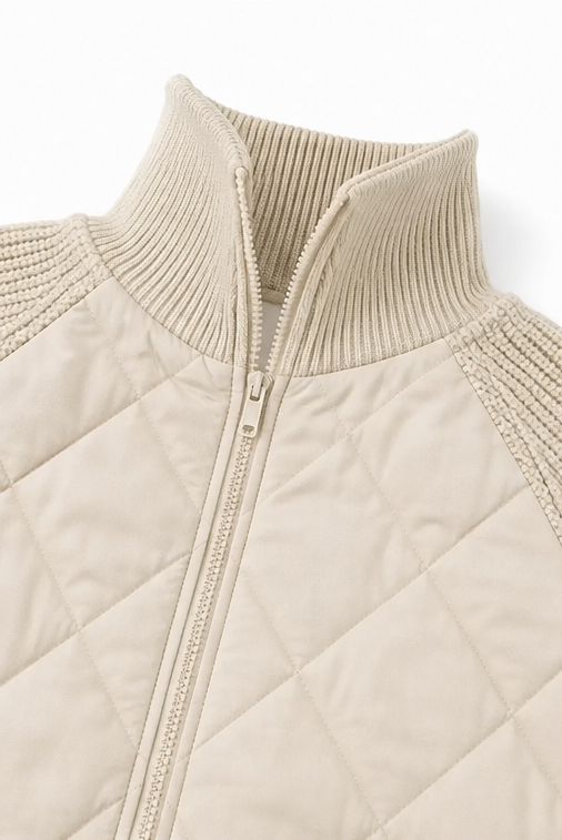 Close up of the ribbed collar and zip on a cream quilted jacket