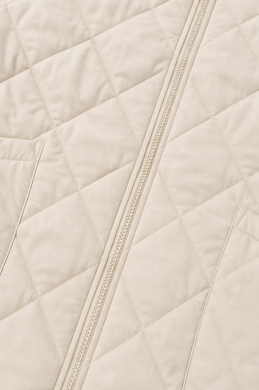 Close up of the diamond quilting and zip on a cream jacket