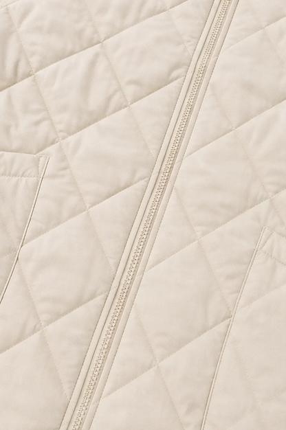 Close up of the diamond quilting and zip on a cream jacket