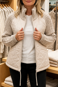 Cream quilted jacket with cable knit sleeves and a stand collar