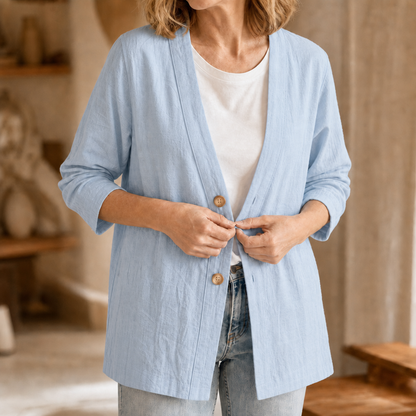 Light blue open V neck cardigan buttoned over a white top