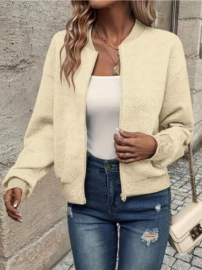 Cream textured knit zip-up cropped bomber jacket worn over jeans
