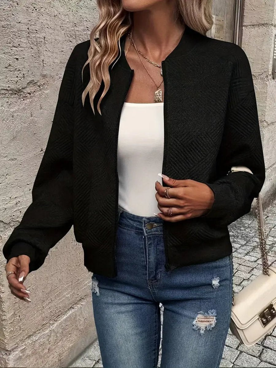 Black textured knit zip-up cropped bomber jacket worn over jeans
