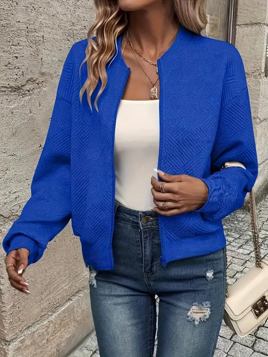 Royal blue textured knit zip-up cropped bomber jacket worn over jeans
