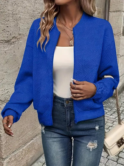 Royal blue textured knit zip-up cropped bomber jacket worn over jeans
