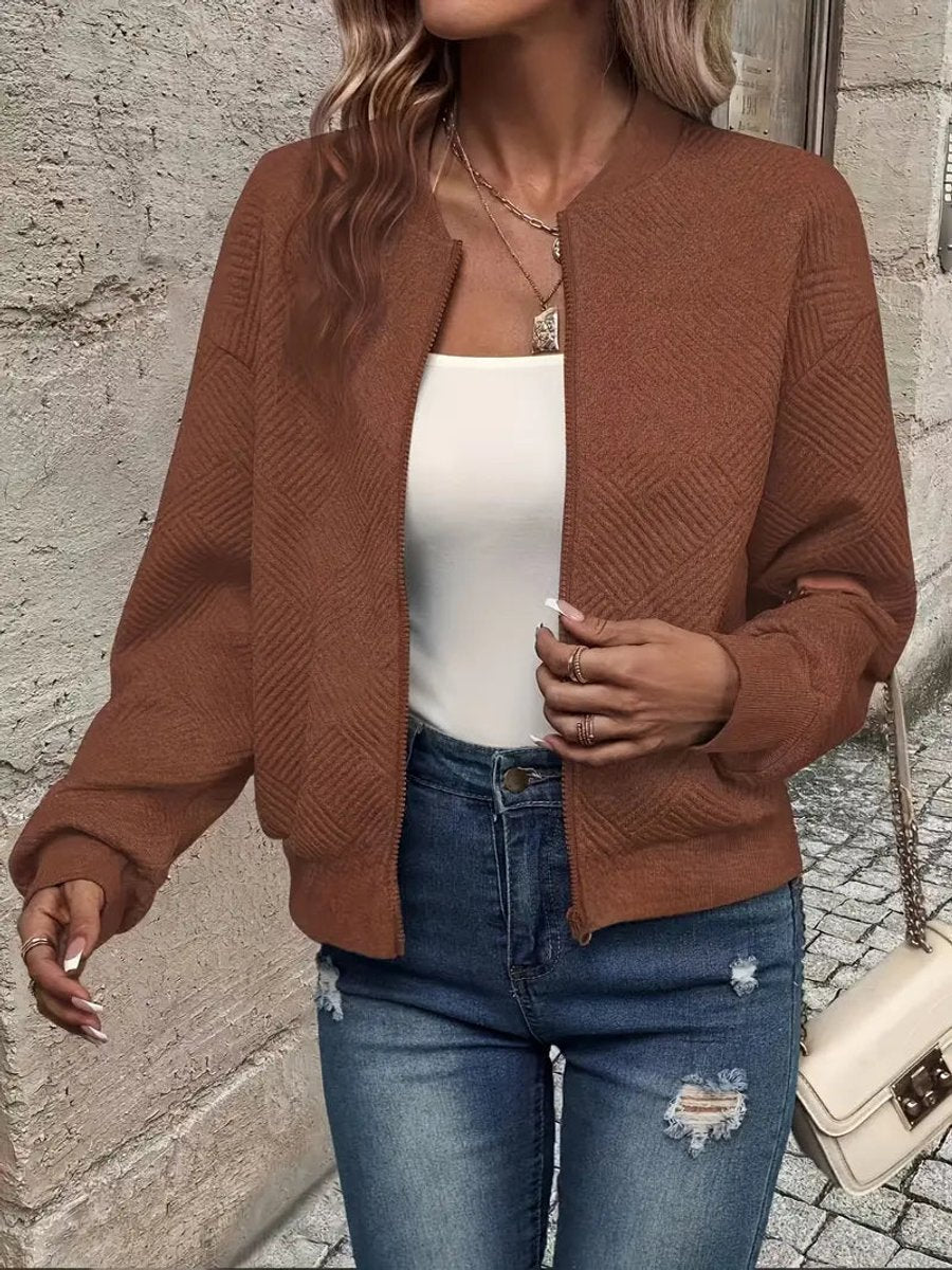 Rust brown textured knit zip-up cropped bomber jacket worn over jeans