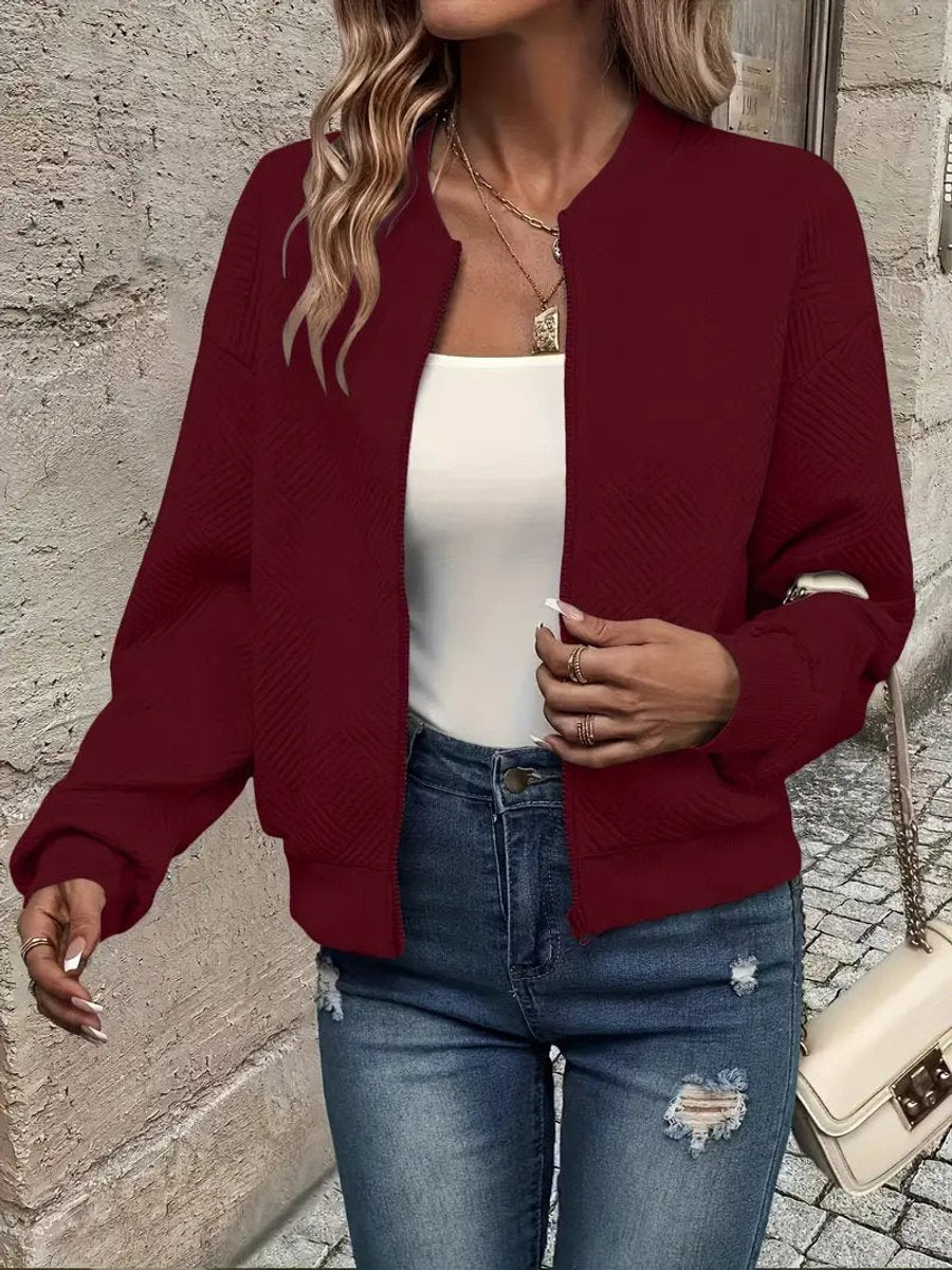 Burgundy textured knit zip-up cropped bomber jacket worn over jeans