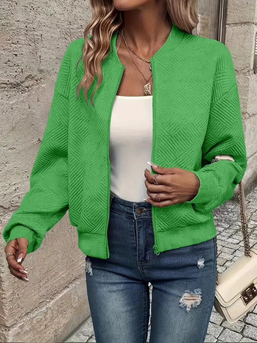 Bright green textured knit zip-up cropped bomber jacket worn over jeans