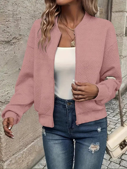 Dusty pink textured knit zip-up cropped bomber jacket worn over jeans