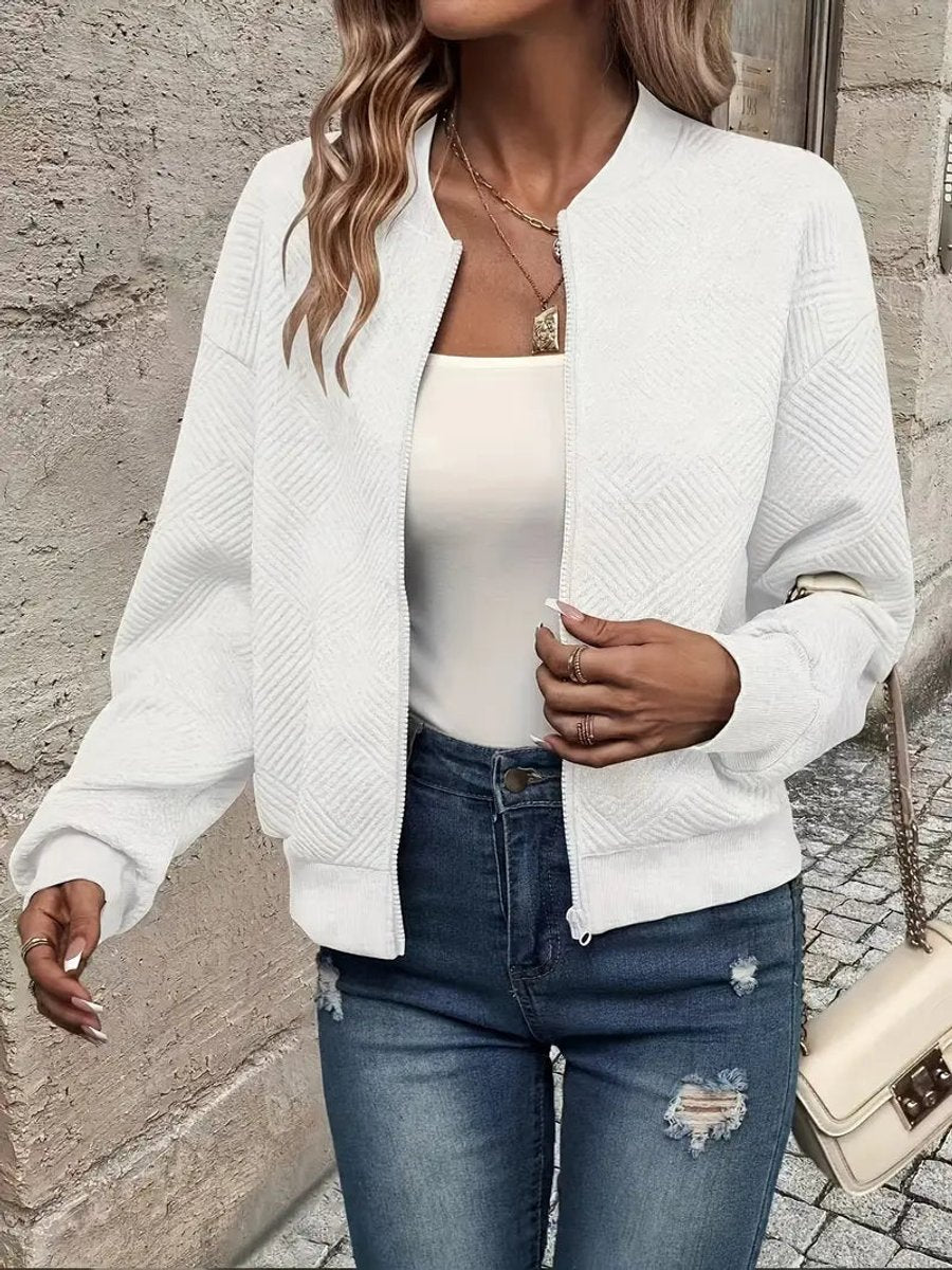White textured knit zip-up cropped bomber jacket worn over jeans