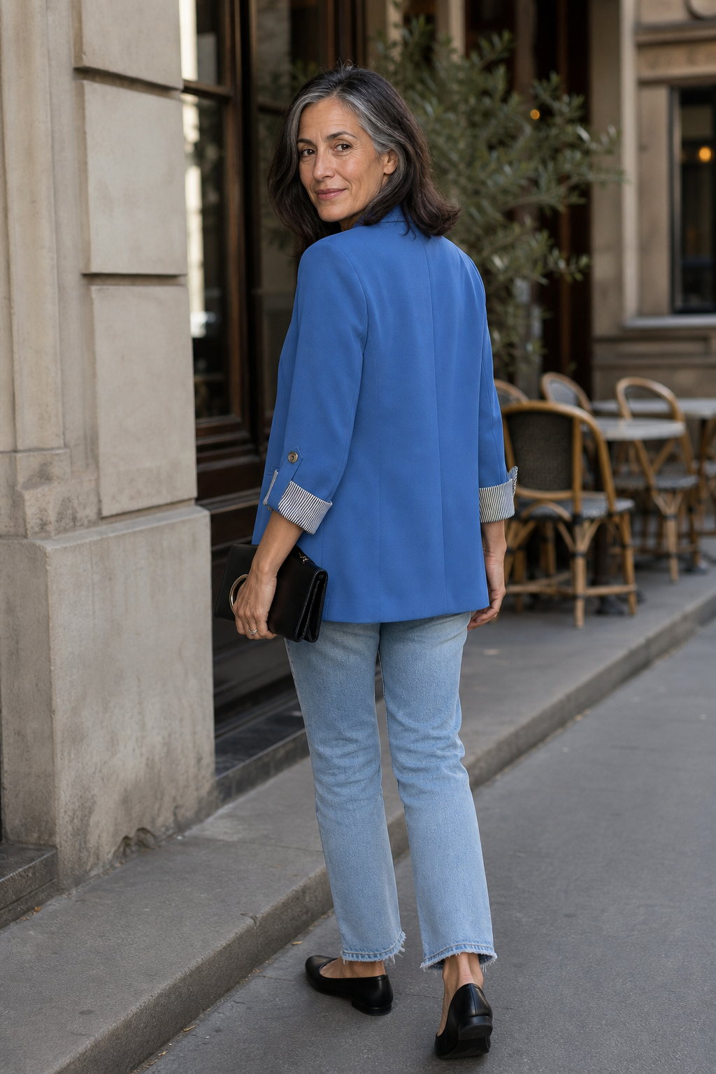 Back view of a blue roll sleeve blazer on a Paris street