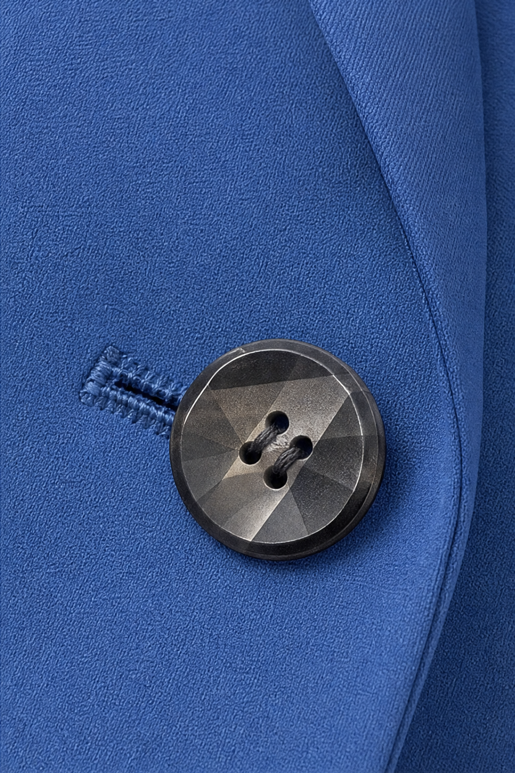Dark horn button and buttonhole on a blue blazer