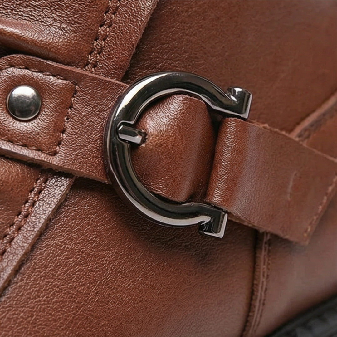 Silver horseshoe buckle detail on a brown ankle boot strap