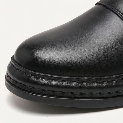 Polished round toe and stitched welt on a black ankle boot