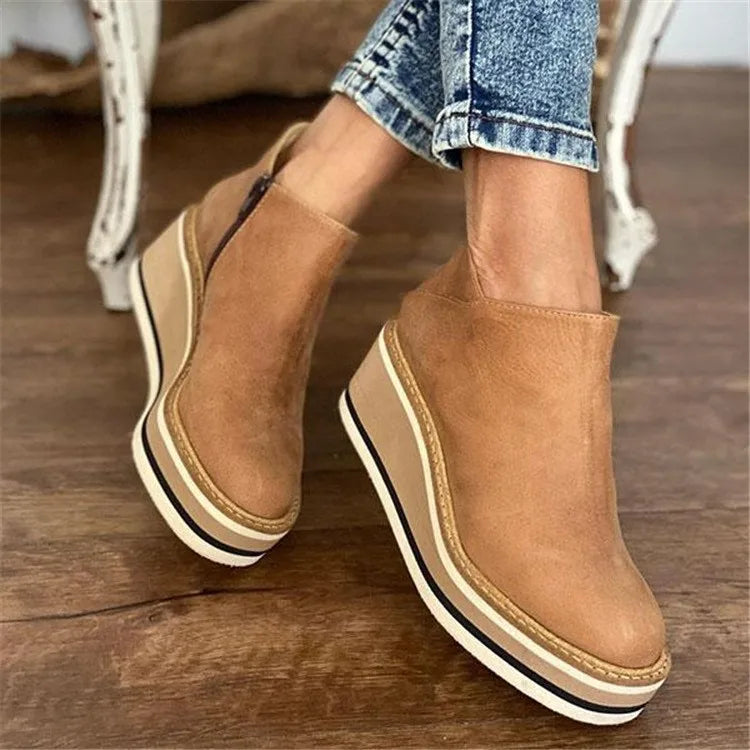 Tan suede ankle boots with a striped wedge sole worn with jeans
