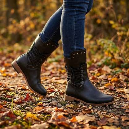 Black studded lace up mid calf boots worn with jeans on an autumn path