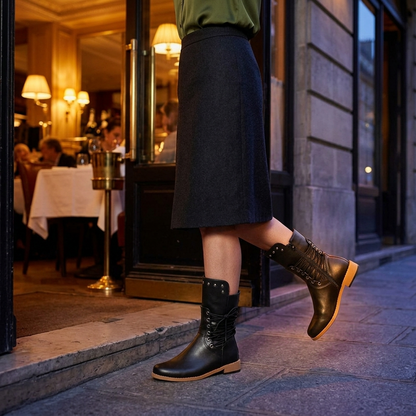 Black lace up boots worn with a charcoal midi skirt on a city street