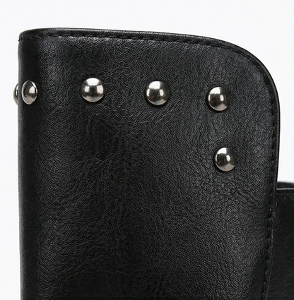 Close-up of the silver studs on the black leather shaft of a lace up boot